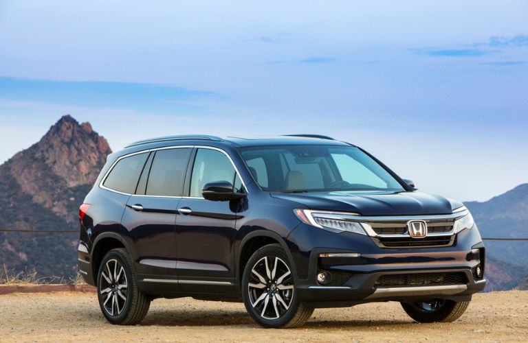 The 2021 Honda Pilot parked near a hill range